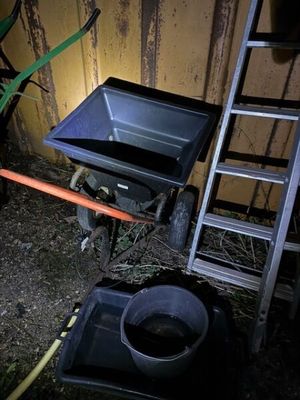 une brouette à côté d'une autre brouette sur laquelle est posé un seau