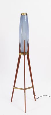 a blue glass lamp on a wooden tripod stand