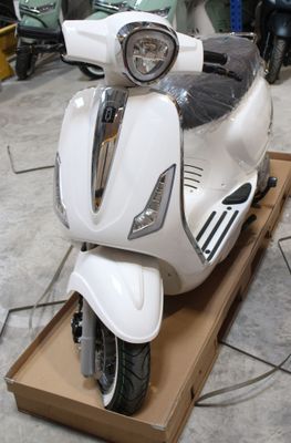 un scooter blanc exposé dans un garage