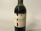une vieille bouteille de vin posée sur une table blanche