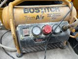 a yellow and black air compressor sitting on the ground