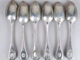 six spoons are lined up in a row on a white surface