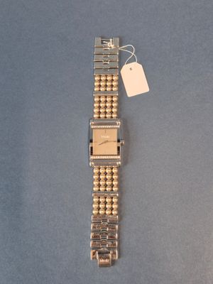 un gros plan d'une montre-bracelet sur laquelle est accrochée une étiquette