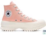 a close up of a pair of pink converses on a white background