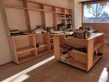 a room with a desk, shelves, and a chair in it