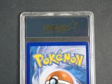 the pokemon card is in a plastic case on a table