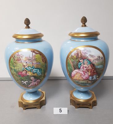 two blue vases with pictures of people on them sitting on a table