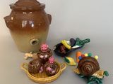 a brown vase, a bowl, and some small figurines on a table