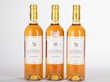 trois bouteilles de vin posées les unes à côté des autres sur une surface blanche