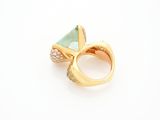 a close up of a gold ring with a green stone and diamonds