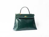 a green leather handbag on a white background