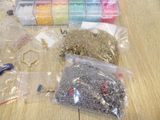 many different types of beads and scissors on the table