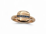 gros plan d'une bague en or avec des saphirs bleus