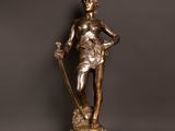 a bronze statue of a woman holding a sword on a table