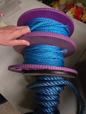 une personne qui tient une bobine de corde bleue