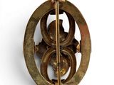 a gold brooch with a circular design on it
