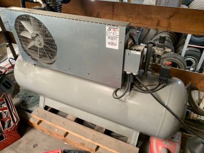 un gros climatiseur posé sur une palette dans un garage