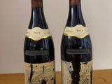 two bottles of wine sitting on top of a table next to each other