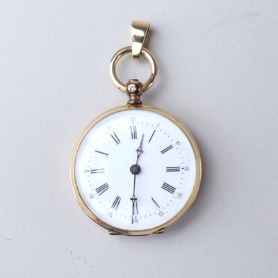 a small gold pocket watch with roman numerals on it
