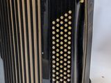 an old accordion sitting on top of a table next to a white wall