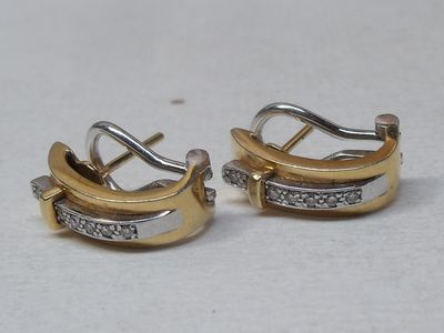 pair of two tone gold and silver earrings with diamonds
