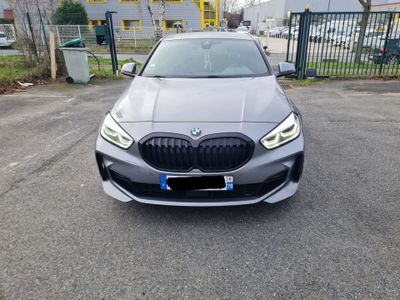 the front of a silver bmw car parked in a parking lot