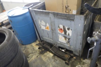une photo d'une benne à ordures dans un garage, remplie de bric-à-brac