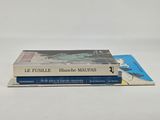 three books are stacked on top of each other on a white surface