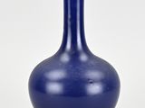 a blue vase that is sitting on a white surface