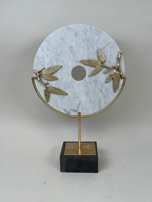 une image représentant un disque en marbre blanc orné de libellules dorées