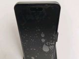 l'arrière d'un téléphone Samsung S9 noir sur lequel se trouvent des gouttelettes d'eau