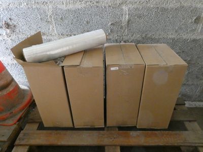 une pile de cartons posée sur une palette à côté d'un cône de signalisation