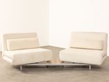 two white chairs sitting next to each other in a room