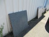 two pieces of granite on the ground next to a building