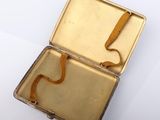 a small metal box with a yellow ribbon in it