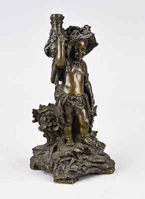 une statue antique en bronze représentant un garçon tenant un panier de fleurs