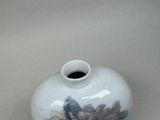 a white vase with a floral design on it