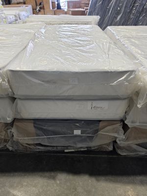 many mattresses stacked on top of each other in a warehouse
