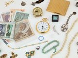 une table blanche sur laquelle sont disposés de nombreux bijoux et une horloge