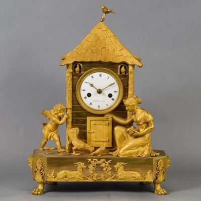 a gold clock sitting on top of a wooden table