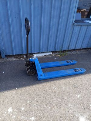 une palette bleue posée par terre à côté d'un bâtiment bleu