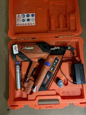 une boîte à outils orange contenant une agrafeuse, une agrafeuse et d’autres outils