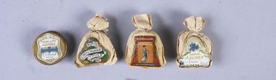 four miniature christmas ornaments are displayed in a row on a white surface