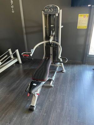 une salle de sport équipée d'un appareil et d'un banc