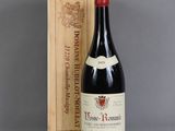 an old bottle of wine sitting next to a wooden box