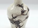 un vase blanc orné d'un motif noir