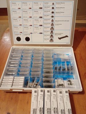 une photo d'une boîte de vis et d'écrous posée sur une table