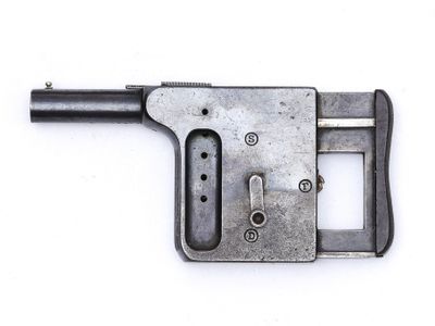 un vieux pistolet posé sur une surface blanche