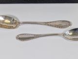 two spoons sitting next to each other on a table