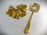 a gold spoon and a gold spoon with a flower on it